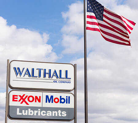 Walthall & Exxon-Mobil signs next to American flag